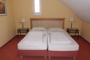 2 Einzelbetten in einem Zimmer mit 2 Lampen in der Unterkunft Ferienwohnung Marko in Neddesitz