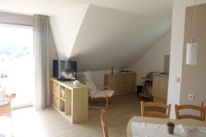 ein Wohnzimmer mit einem TV und einem Tisch mit Stühlen in der Unterkunft Ferienwohnung Marko in Neddesitz