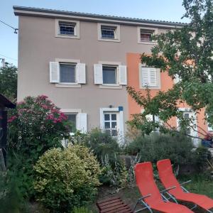 due sedie rosse davanti a una casa di Orange Cube Apartment - Self check in - Free parking a Fiume (Rijeka) Altre 38 foto