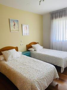 メアニョにあるTu hogar en el corazón de O Salnésのベッドルーム1室(ベッド2台、窓付)