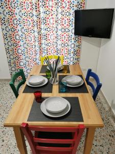 un tavolo in legno con piatti e utensili. di Dimora Castellini a Ragusa