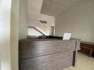 a kitchen with a wooden dresser with a laptop on it at OYO 91419 Hotel Mulia Bangka in Pangkalpinang