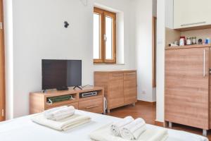 a bedroom with a tv and a bed with two towels at Apartment Lucky in Budva