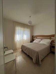 a bedroom with a bed and a chair and a window at Curri Case al Mare in Monopoli