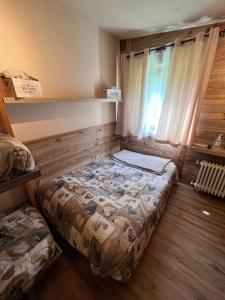 a small room with a bed and a window at CASA CERVINIA SHUSS 2 in Breuil-Cervinia