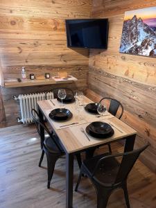 a wooden table with chairs and wine glasses on it at CASA CERVINIA SHUSS 2 in Breuil-Cervinia