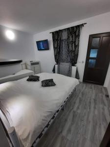 a bedroom with a large white bed and a window at Casa Marștef in Eforie Sud