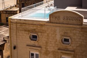a building with a sign on top of it at The Segond Hotel in Xagħra