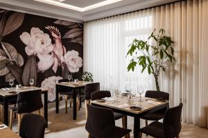 a restaurant with tables and chairs and a floral mural at The Segond Hotel in Xagħra
