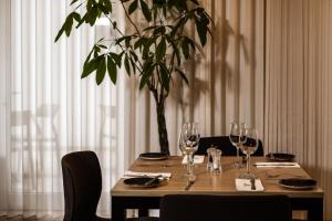 a wooden table with wine glasses and a potted plant at The Segond Hotel in Xagħra