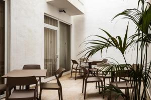 a restaurant with tables and chairs and a plant at The Segond Hotel in Xagħra