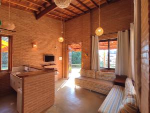 a room with a kitchen and a living room with windows at Encantos do Vale Pousada e SPA Cultural in Bueno Brandão