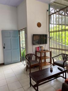 a living room with a blue door and a table and chairs at Blue Morpho House B&B in Manuel Antonio