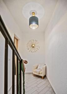 un couloir avec une chaise et un réveil sur le mur dans l'établissement Beneduce B&B ROOMS, à Santa Maria di Castellabate