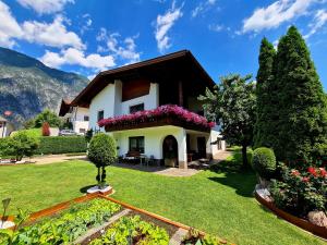 a house with flowers on the front yard at ALPTyrol in Rifenal