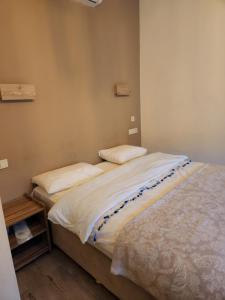 um quarto com 2 camas e lençóis brancos em Mersu A'la Konak Otel em Sapanca