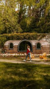 a woman walking down a path in front of a trailer at Enniskeen Estate & Forest Spa - Boutique Riverside Glamping Cabins in Newcastle