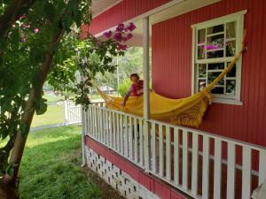 a boy is playing in a hammock on a porch at Casa de campo 2 bela Wifi in Urubici