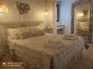 um quarto com uma cama grande e toalhas em Lampi's House em Patmos