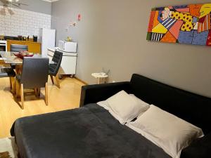 um quarto com uma cama e uma sala de jantar em Locflat Mirante 211 Centro Gramado em Gramado