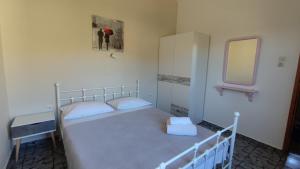 a small bedroom with a bed and a mirror at Tramonto Nel Delfini in Kini