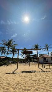 a volley ball hoop on a beach with palm trees at Pousada da Barra Caraíva in Caraíva