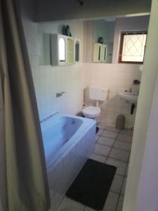 a bathroom with a bath tub and a toilet at Edward Cabana in Margate