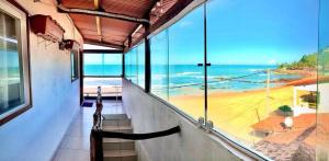 a balcony with a view of a beach and the ocean at Pé na Areia in Baía Formosa