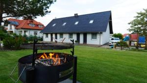 a fire pit in a yard with a house at Apartamenty Leśny Zakątek in Dziemiany