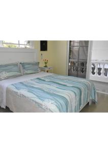 a bedroom with a bed with a blue and white blanket at RELAX @ BEACH, BIBIJAGUA in Punta Cana