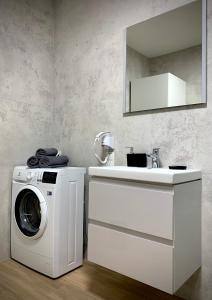 uma casa de banho com uma máquina de lavar roupa e um lavatório em APARTAMENT SARBINOWO Z OGRÓDKIEM em Sarbinowo