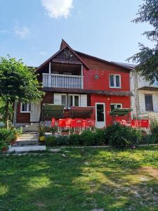 a red house with red chairs in front of it at Cabana Silvia in Gheorgheni
