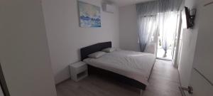 - une chambre blanche avec un lit et une fenêtre dans l'établissement Apartment Rupena, à Klimno