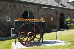 a wooden wagon with flowers in front of a building at Herberg de Brabantse Kluis in Aarle-Rixtel