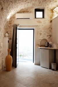 kuchnia z dużymi drzwiami w kamiennej ścianie w obiekcie white room Ostuni w mieście Ostuni