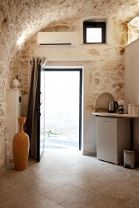 a kitchen with a large door in a stone wall at white room Ostuni in Ostuni