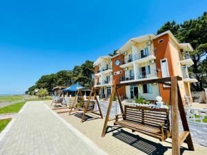 un bâtiment avec un groupe de bancs en bois à côté de la plage dans l'établissement Sea Line Hotel, à Shekvetili