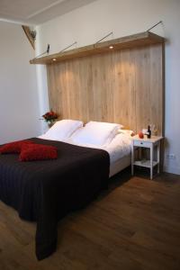 una camera con un grande letto e una parete in legno di Herberg de Brabantse Kluis ad Aarle-Rixtel