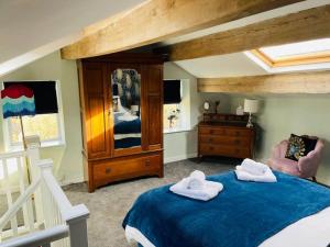 een slaapkamer met een bed met twee handdoeken erop bij Tipple Cottage in Haworth