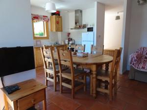 kuchnia i jadalnia z drewnianym stołem i krzesłami w obiekcie Chalet La Ruche w mieście Saint-Sorlin-dʼArves