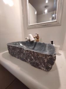lavabo de piedra en la encimera del baño con espejo en Traditional suites in Chora Kythnos #3, en Kithnos