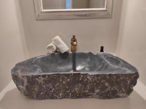 - kamienną umywalkę w łazience z lustrem w obiekcie Traditional suites in Chora Kythnos #3 w mieście Kitnos