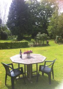 a table with two chairs and a bottle and flowers on it at Wye Valley near Tintern Abbey Charming cottage within farmhouse Rocklea Farm,Broadstone, Trellech Monmouthshire in Monmouth