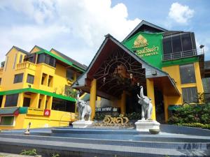 a yellow building with two statues in front of it at Inn Come Hotel Chiang Rai in Chiang Rai +14 photos