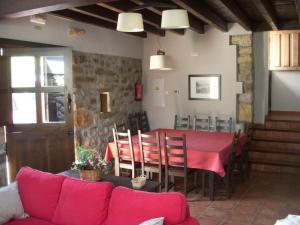 uma sala de estar com uma mesa vermelha e um sofá em La Cuétara de Linares em Ribadesella