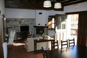 a living room with a couch and a table and a fireplace at La Cuétara de Linares in Ribadesella +24 photos