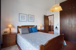 a bedroom with a large bed with blue pillows at Sao Bernardino Beach House in Atouguia da Baleia