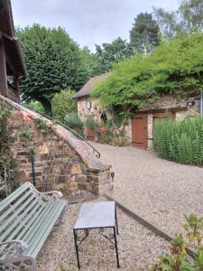 a garden with a green bench and a building at Ground floor stylish french holiday home in Arnac-Pompadour