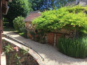 un giardino con un piccolo edificio con un orologio di Ground floor stylish french holiday home ad Arnac-Pompadour