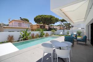 a patio with a table and chairs next to a swimming pool at Lola Sea Villa in Novo Sancti Petri
